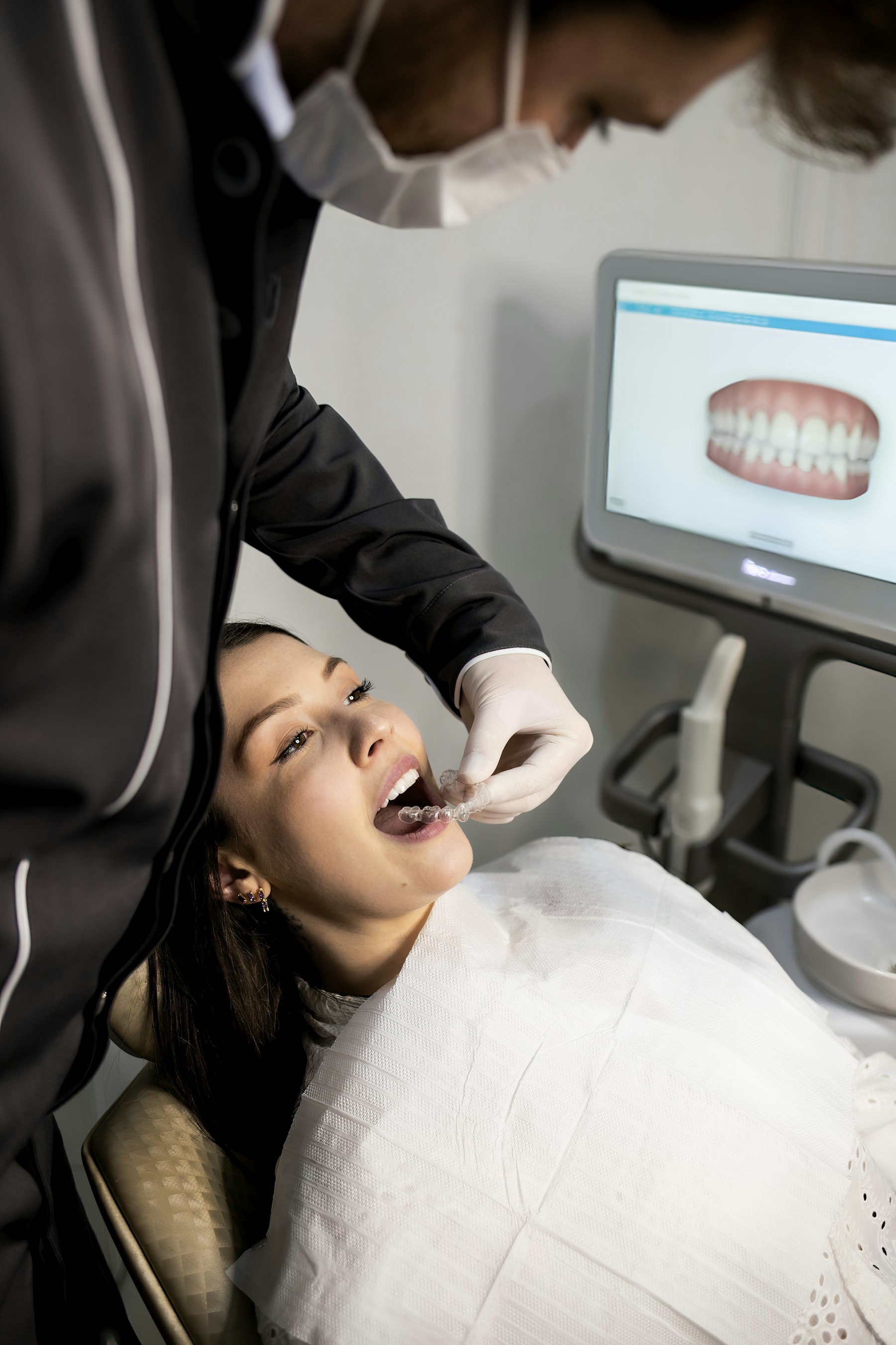 Profissional utilizando scanner intraoral digital para avaliar a arcada dentária de uma paciente